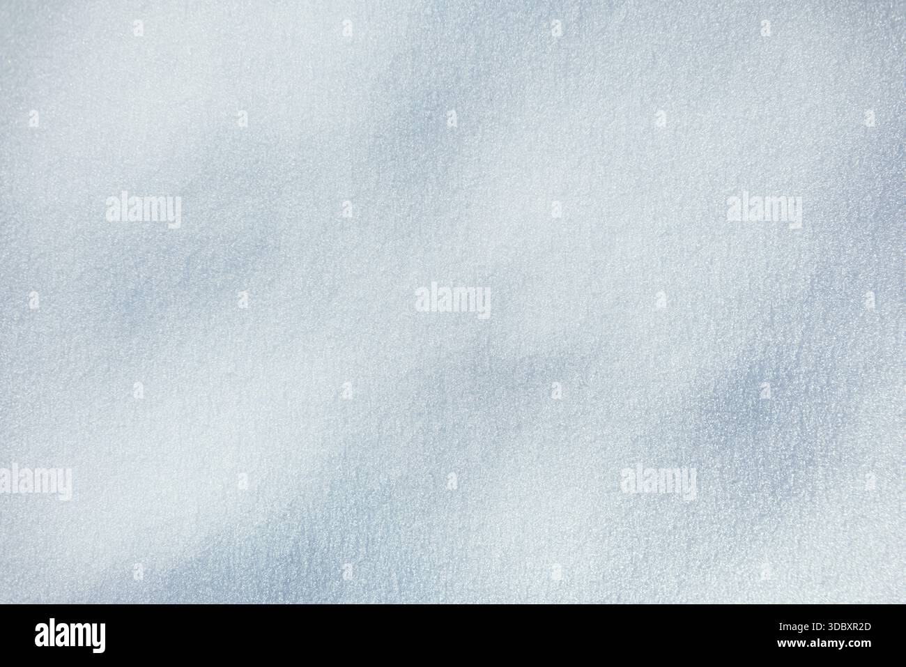 Texture de neige. Surface de neige brillante et étincelante avec cristaux de glace délicats et ombres bleues douces. La lumière du soleil attrape la neige fraîche texturée, créant Un Banque D'Images