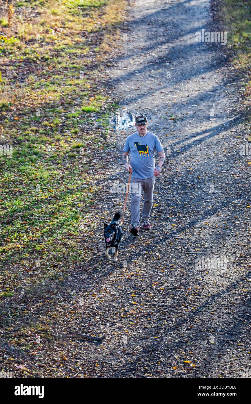 Washington, DC - Un homme promène son chien sur le Kingman Island Trail. Kingman Island est dans la rivière Anacostia. Banque D'Images