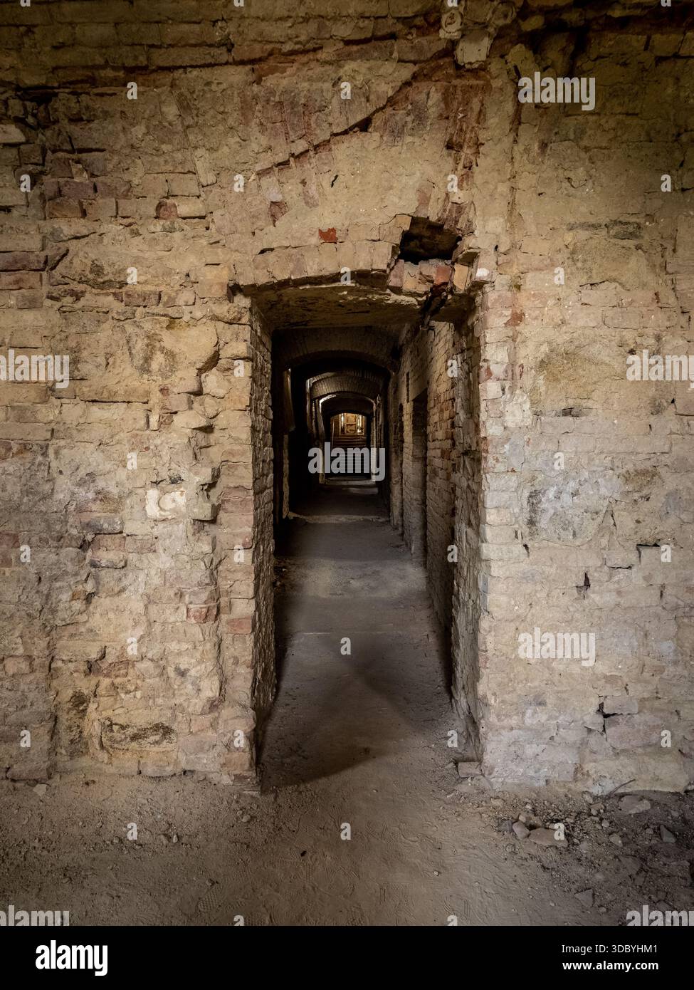 Corridor en briques voûtées dans un château abandonné avec des escaliers éloignés Banque D'Images