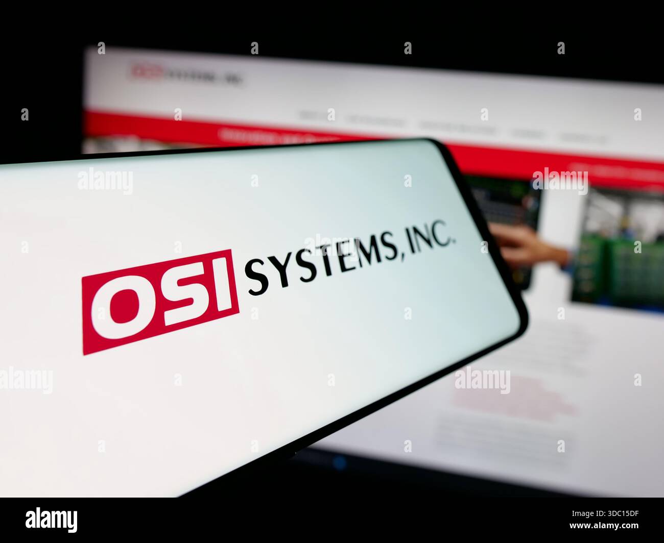 Dans cette illustration photo, un smartphone avec le logo de la société de sécurité américaine OSI Systems Inc est vu sur l'écran devant le site Web. Banque D'Images