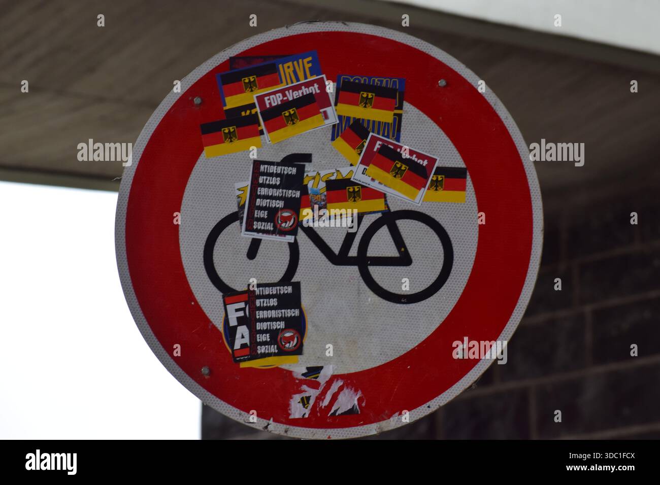 Panneau de signalisation presque recouvert d'autocollants indiquant les conflits en Allemagne Banque D'Images