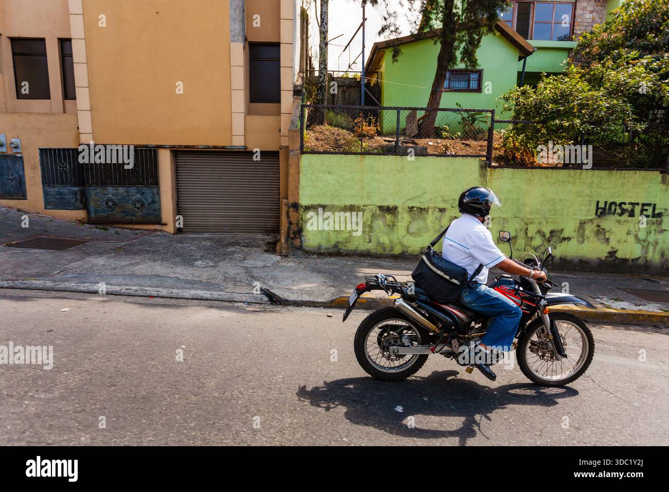 Un homme conduit une moto le long d'une rue colorée au Costa Rica Banque D'Images