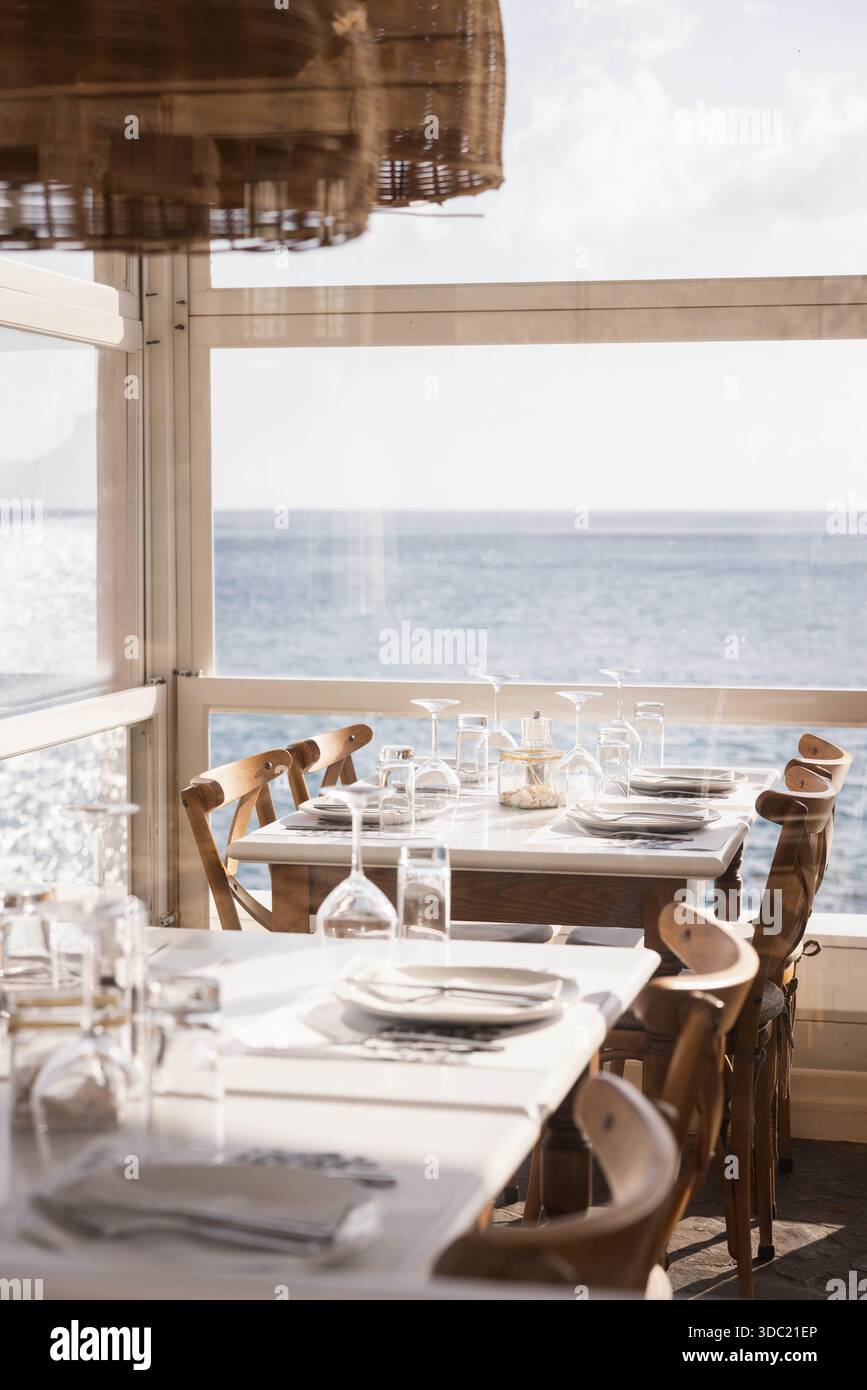 Élégant intérieur de restaurant en bord de mer avec vue sur l'océan tables à manger pour le service, Crète Grèce. Restaurant méditerranéen en bord de mer avec vue sur la mer. Banque D'Images