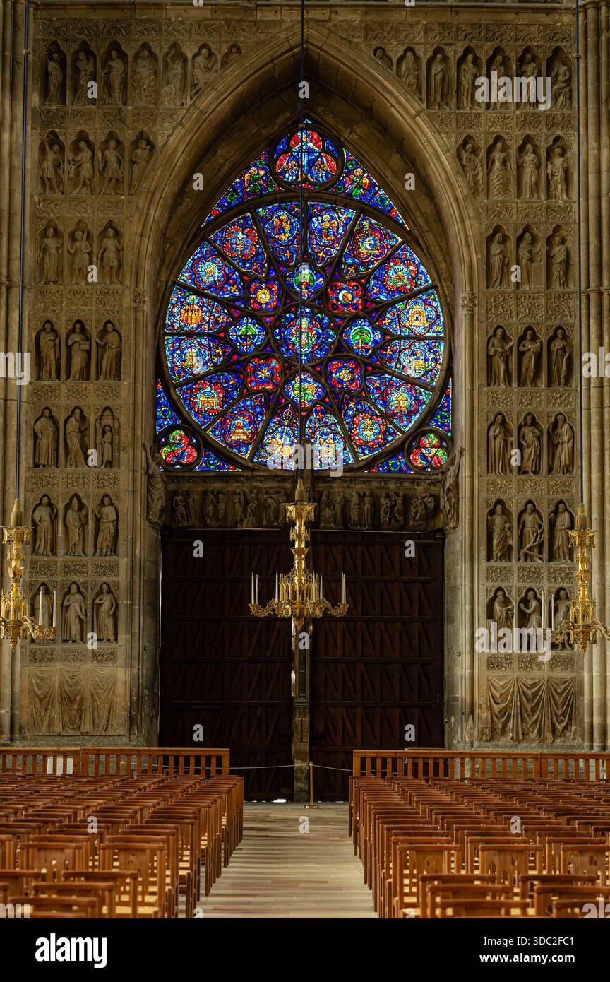 Vue intérieure de l'entrée voûtée de la cathédrale de Reims, avec une rosace, des statues sculptées et des portes en bois ornées dans des détails gothiques époustouflants. Banque D'Images