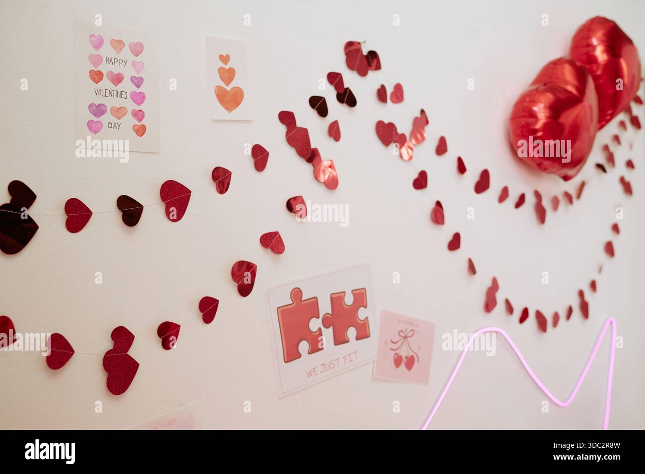 Décorations de coeur de Saint-Valentin accrochées au mur célébrant des vacances romantiques Banque D'Images
