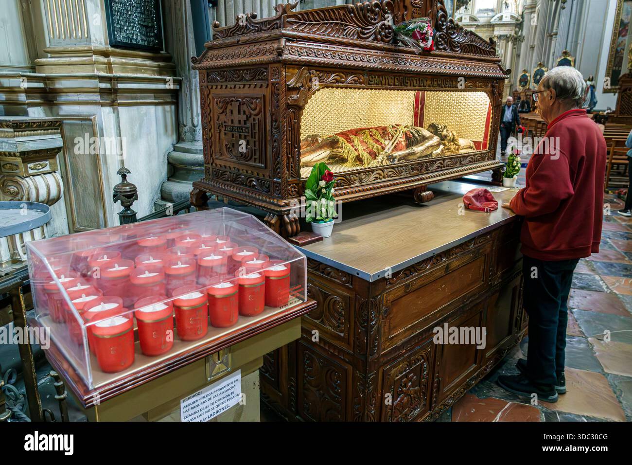 Puebla Mexique,Cathédrale de Catedral Basilica de Puebla,reliquaire intérieur de cathédrale,figure sacrée cercueil en verre,bougies votives rouges offrant,homme âgé Hi Banque D'Images