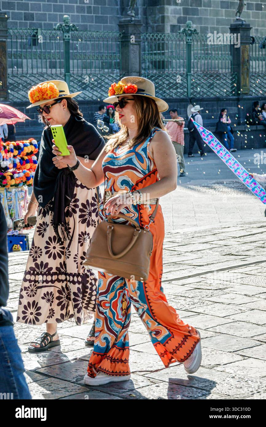 Puebla Mexique, parc de place de la ville de Zocalo, femmes adultes, marcher ensemble, porter des chapeaux, robes colorées, utilisation de smartphone, prendre des photos, place publique, jour s Banque D'Images