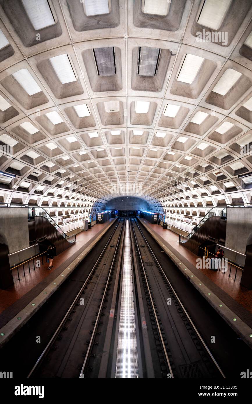 Crystal City Metro Station Arlington Virginie // ARLINGTON, VIRGINIE, États-Unis — Crystal City Metro Station, qui fait partie du réseau de métro de Washington, est réputée pour son architecture brutaliste distinctive. Conçue par Harry Weese, la station présente un plafond en béton voûté à caissons et de longues plates-formes. Il sert d'arrêt important sur les lignes bleue et jaune de la Washington Metropolitan Area transit Authority (WMATA). Ce style architectural emblématique est caractéristique de nombreuses stations de métro dans toute la région métropolitaine de Washington D.C. Situé dans le quartier Crystal City Banque D'Images