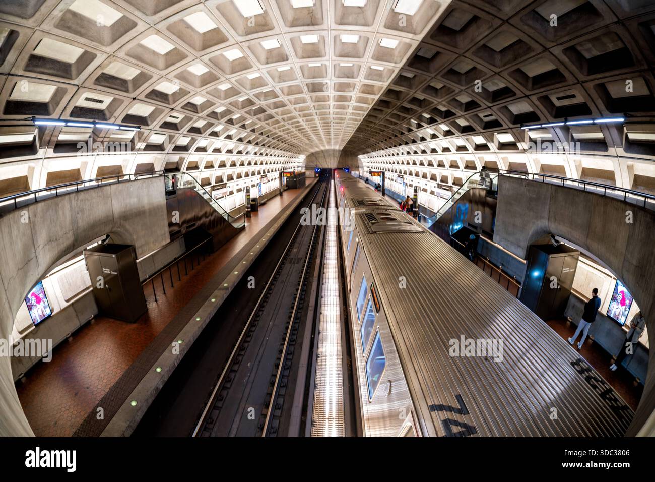 Crystal City Metro Station Arlington Virginie // ARLINGTON, Virginie — L'architecture brutaliste distinctive de la station de métro Crystal City est visible avec un train arrêté au quai. Cette station de métro, qui fait partie du réseau du métro de Washington, présente des voûtes en béton à caissons emblématiques conçues par l'architecte Harry Weese. La station dessert le quartier de Crystal City à Arlington, en Virginie, reliant les navetteurs à Washington D.C. et à la région métropolitaine. Son design unique, caractérisé par du béton exposé et des motifs géométriques répétitifs, est une caractéristique du système WMATA. Banque D'Images