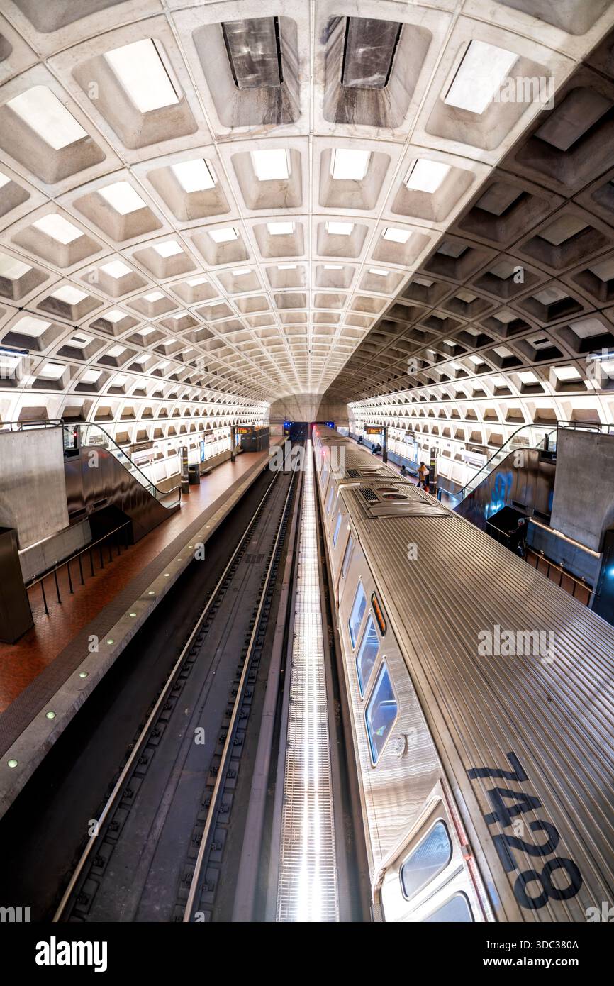 Train de métro de Washington à Crystal City Station Arlington Virginie // ARLINGTON, Virginie — Un train de métro de Washington est à Crystal City Station à Arlington, Virginie. Le train en acier inoxydable, portant le numéro de wagon 748, est visible sur l'une des voies. La station présente le plafond emblématique de la voûte en béton à caissons, un élément architectural caractéristique du système WMATA (Washington Metropolitan Area transit Authority). Conçu par Harry Weese, ce style d'inspiration brutaliste définit de nombreuses stations de métro dans la région métropolitaine de Washington D.C. Banque D'Images