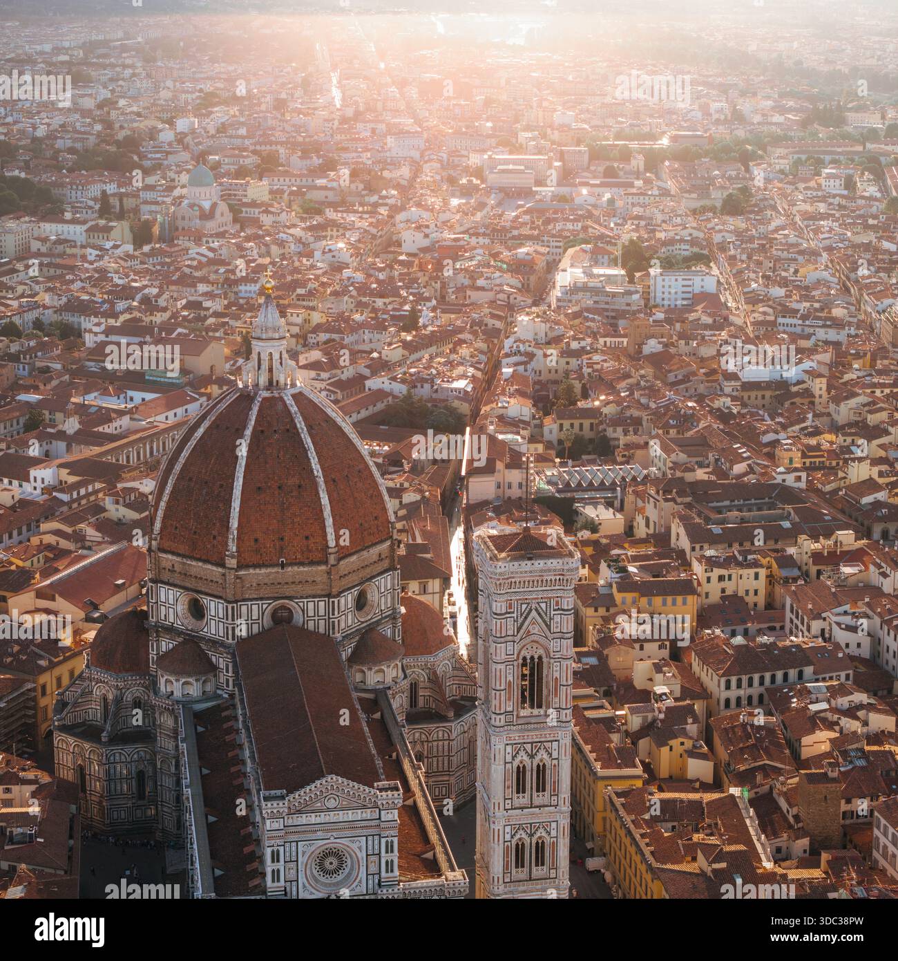 Vue aérienne des toits en terre cuite qui s'étendent vers l'horizon, dominés par l'emblématique Duomo et le Campanile de Giotto, Florence, Toscane, Italie. Banque D'Images