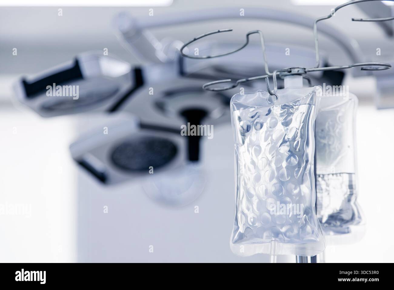 Les sacs IV sont suspendus dans une salle d'opération propre, avec des lampes et des instruments chirurgicaux modernes, soulignant l'importance des soins de santé et de la médecine Banque D'Images