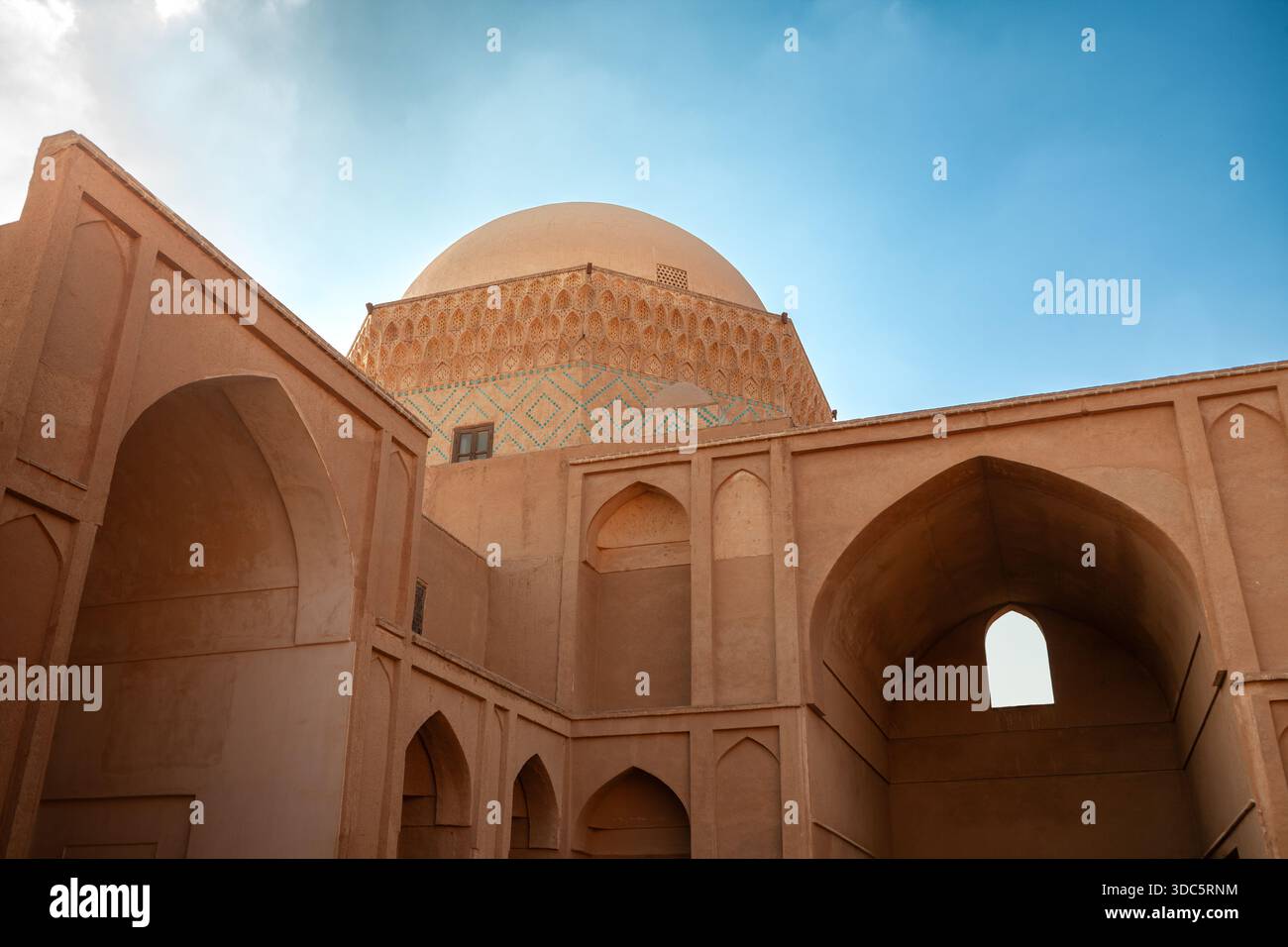 Une image d'une structure iranienne traditionnelle en adobe avec des arches pointues et un grand dôme avec des motifs géométriques complexes de tuiles et des sculptures décoratives. Banque D'Images