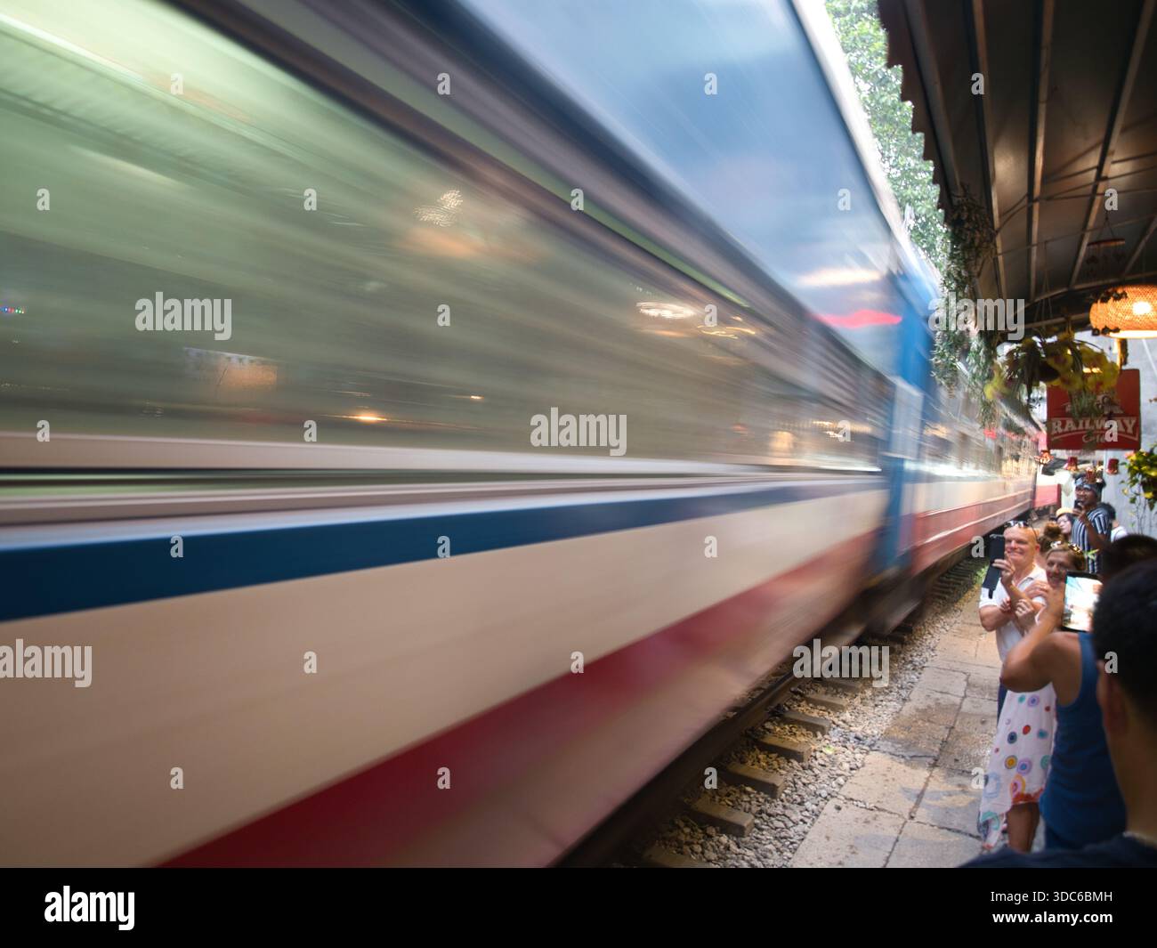 hanoi-Vietnam-10 août 2019,HANOI, VIETNAM - les touristes regardent un train vietnamien à grande vitesse passer dangereusement près de la voie ferrée étroite dist Banque D'Images