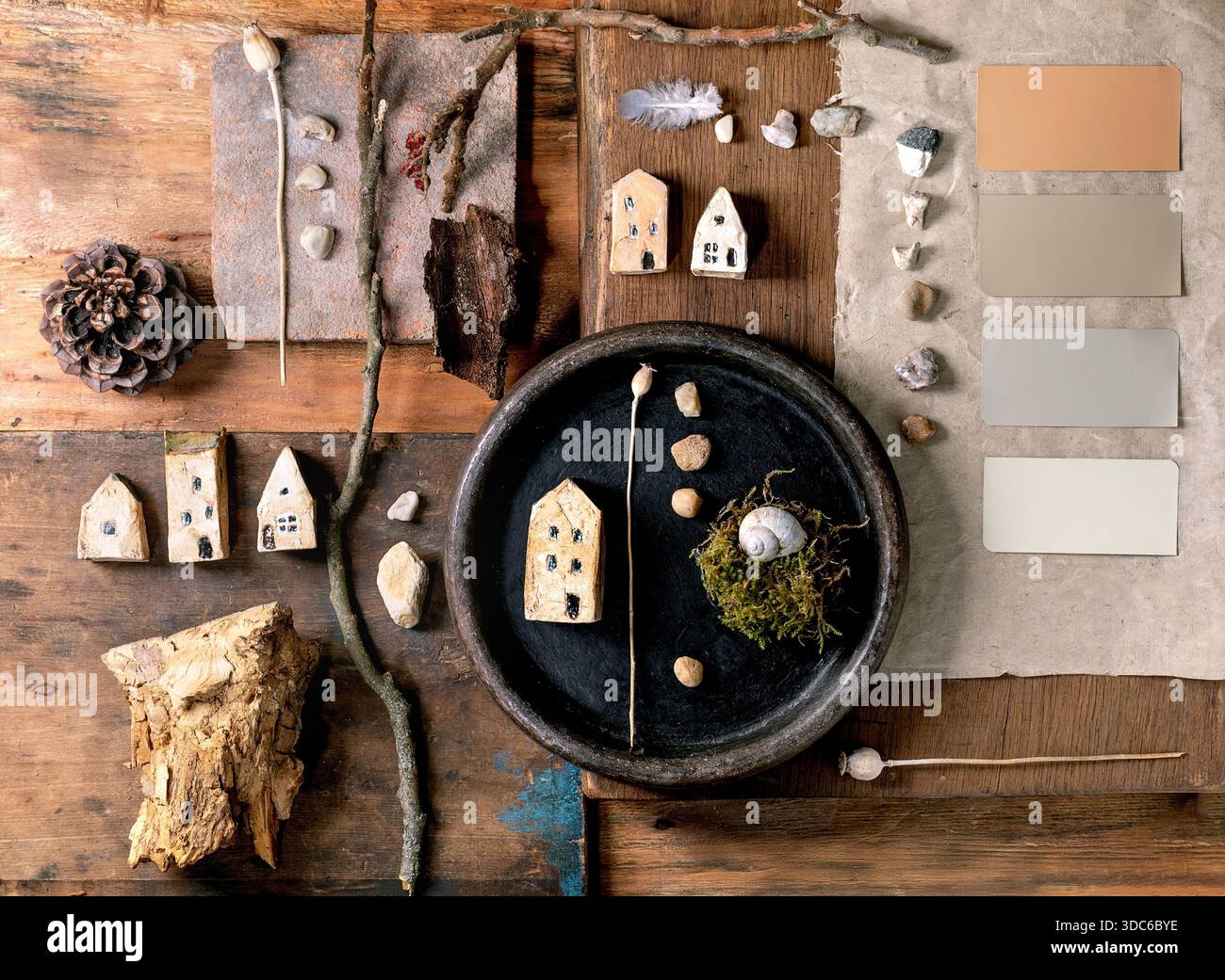 Flat lay Creative Design composition maisons miniatures en céramique, galets, coquille, mousse sur fond de bois. Arrangement de matériaux naturels avec PAL de couleur Banque D'Images