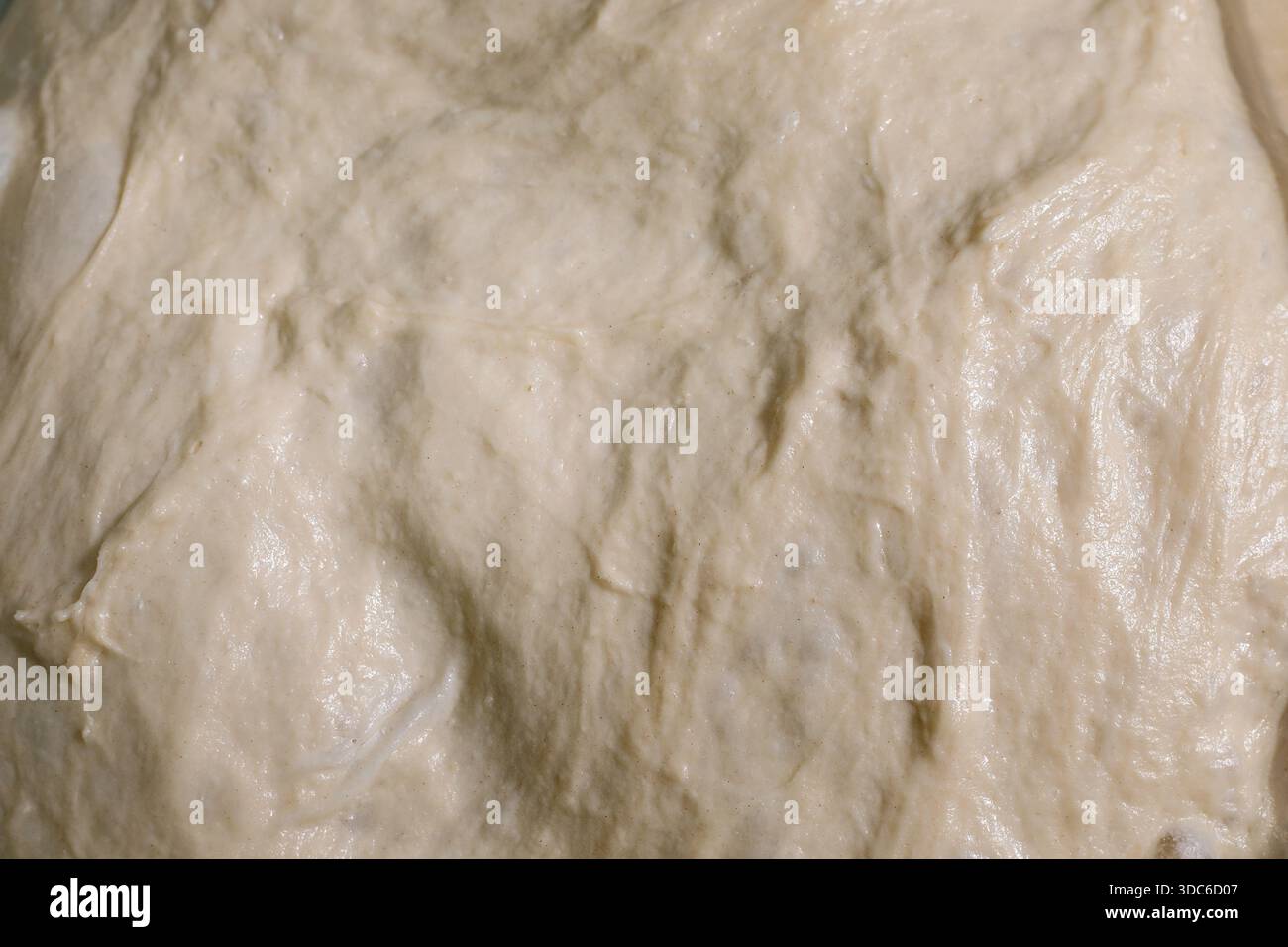 Gros plan sur la texture de la pâte à levure maison. Pâte à pain crue prête pour la cuisson. Plan macro de mélange de farine blanche lisse. Banque D'Images