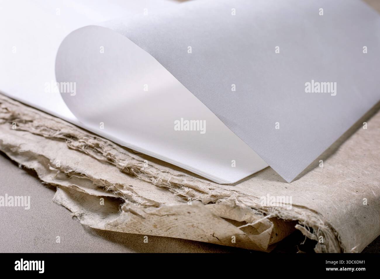 Feuille de papier blanc propre de riz et de mûrier placée sur du papier texturé fait à la main avec des bords rugueux. Composition minimaliste soulignant le contraste entre smo Banque D'Images