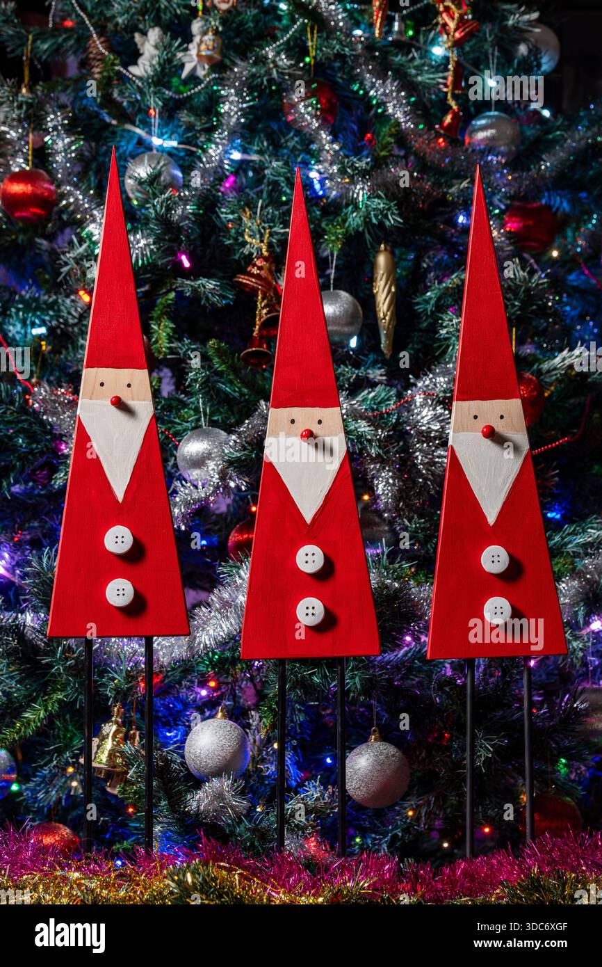 Ornements décoratifs de Noël d'hiver : trois gnomes fantaisistes comme symbole de bonne chance dans la nouvelle année. Gnomes en bois faits à la main avec des chapeaux rouges contre t Banque D'Images