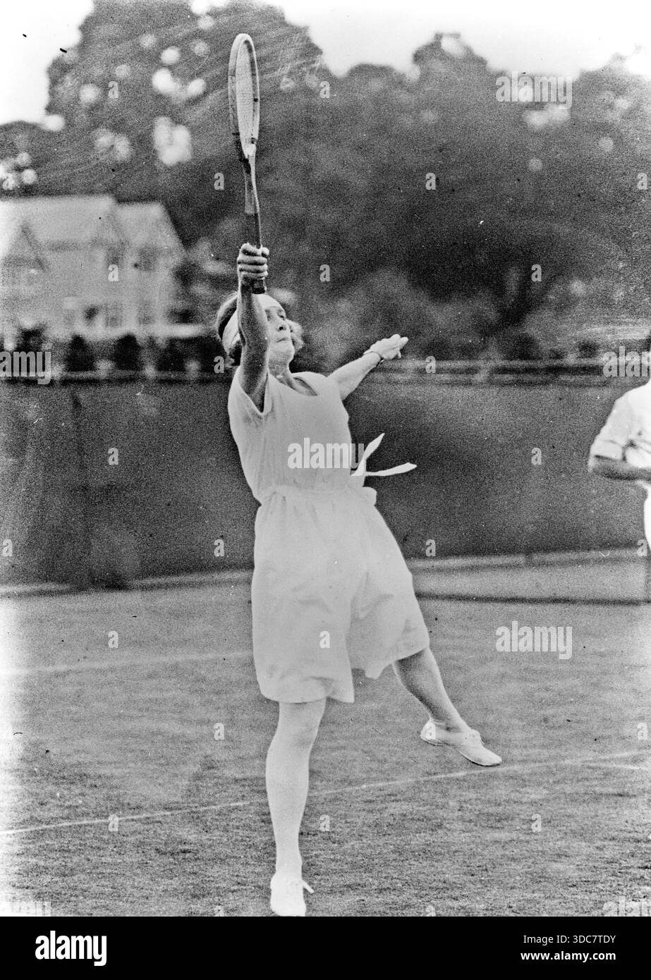 La joueuse de tennis britannique Evelyn Colyer aux Championnats de Wimbledon 1922 jouant au premier tour de l'épreuve de double mixte avec Cotah Ramaswami. Banque D'Images