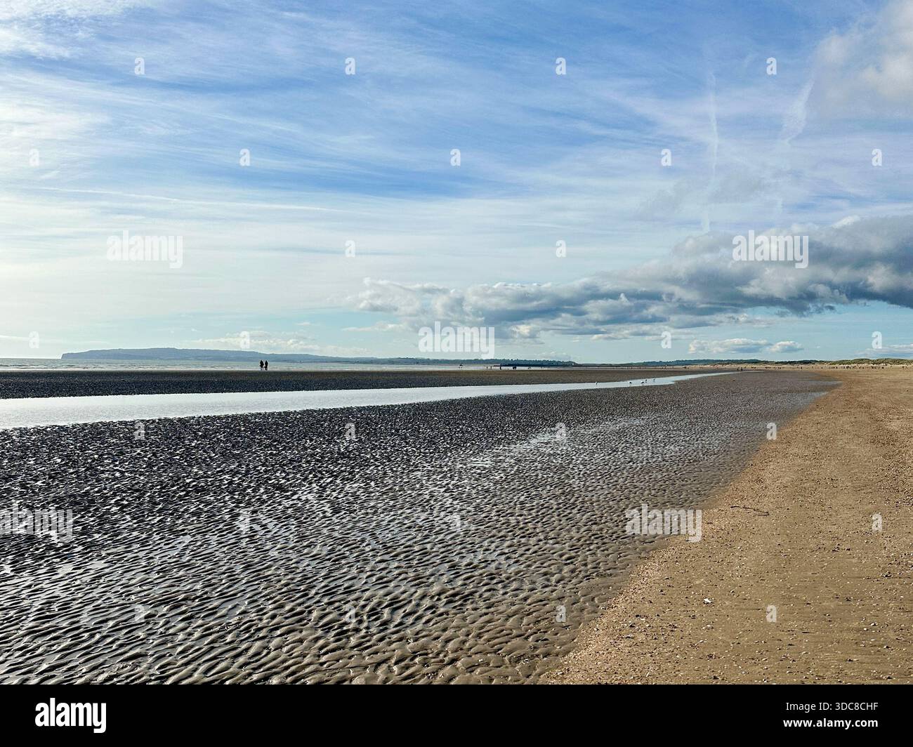 Camber Sands, East Sussex - une vaste plage ondulée à marée basse, avec des bassins de marée et des promeneurs éloignés ajoutant de l'échelle Banque D'Images