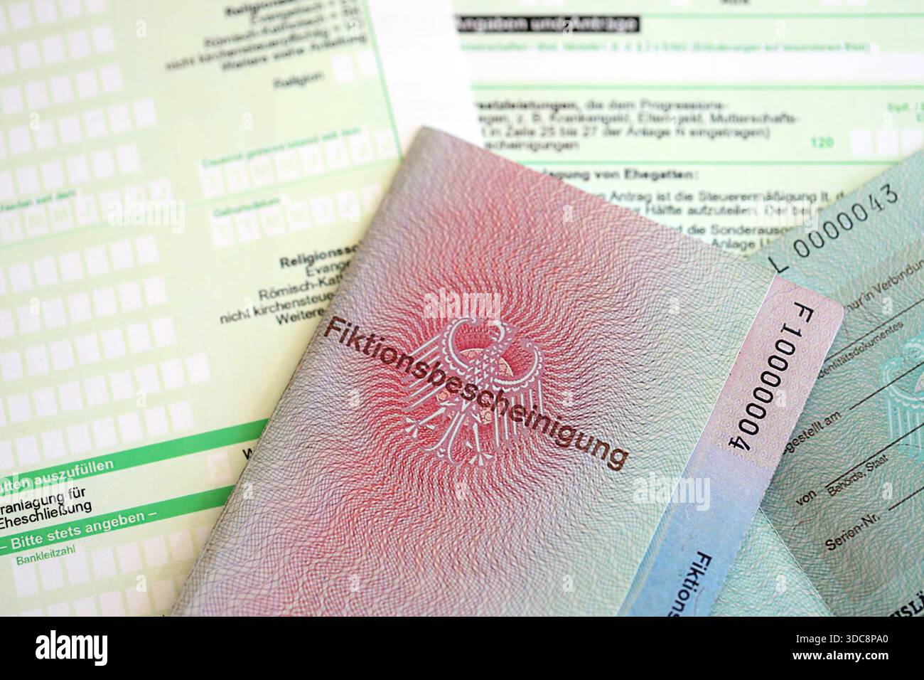 Le spécimen de carte de résident permanent temporaire allemand se trouve sur le formulaire fiscal allemand close up. Fiktionsbescheinigung et einkommensteuerklarung Banque D'Images