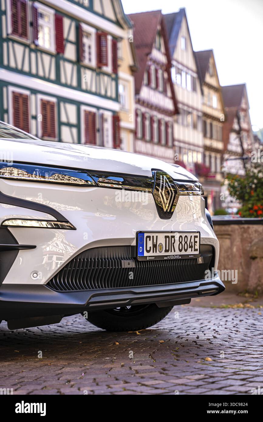 Gros plan d'une voiture blanche avec des maisons à ossature reflétant sur la carrosserie, Deer E-Carsharing, Renault Megane, Calw, Allemagne Banque D'Images