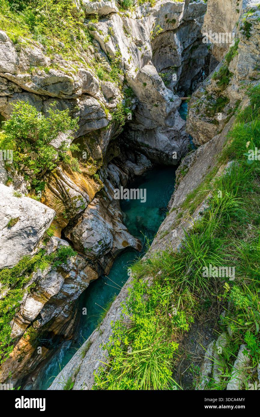 Une vue aérienne à couper le souffle capture la beauté sereine des eaux émeraude qui casquent à travers des canyons accidentés, évoquant l'aventure et la tranquillité en slovène Banque D'Images