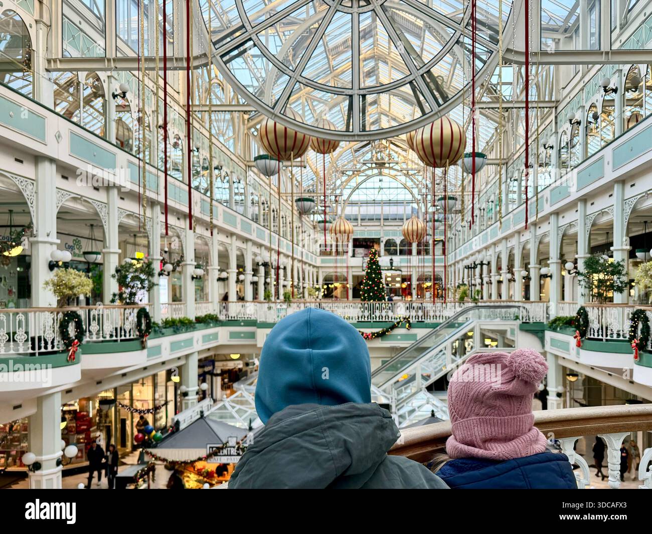 Deux enfants regardant l'intérieur du centre commercial St Stephen's Green à Dublin, en Irlande, décoré pour la saison des fêtes. Banque D'Images