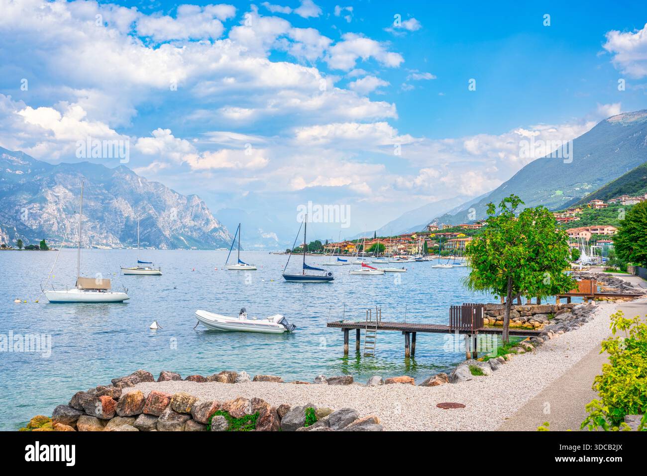 Vue panoramique sur le lac des voiliers amarrés et une piste cyclable en bord de mer à Malcesine, Vénétie. Paysage d'été sur le lac de Garde, Italie Banque D'Images