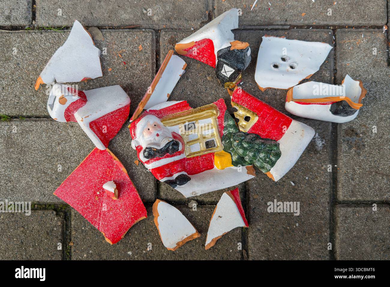 Des poteries brisées représentant le Père Noël et une maison se trouvent sur un trottoir, une image symbolique du conflit et de la dépression pendant la saison des fêtes Banque D'Images