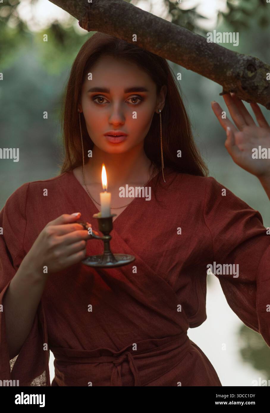 Portrait en gros plan d'une fille magnifique dont le visage est mis en évidence par la flamme chaude de la bougie. Concept de beauté naturelle, chaleur, et un mystérieux, romantique Banque D'Images