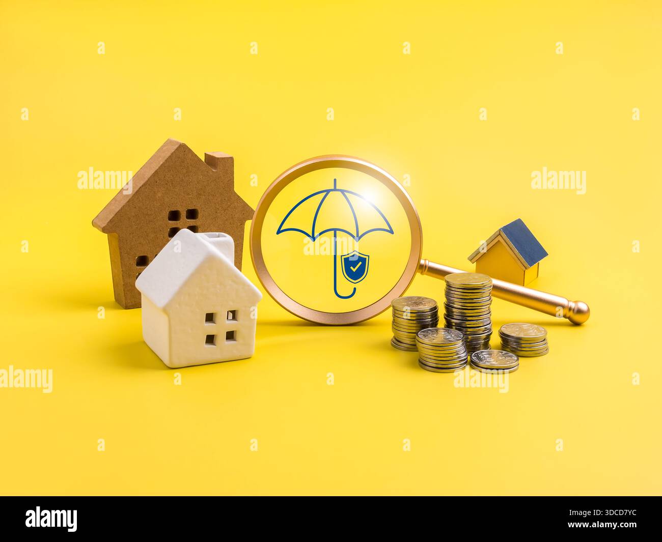 Assurance habitation et concept de protection des biens avec des modèles de maison, des pièces de monnaie et une icône de parapluie sous la loupe. Symbolise la sécurité financière, asse Banque D'Images
