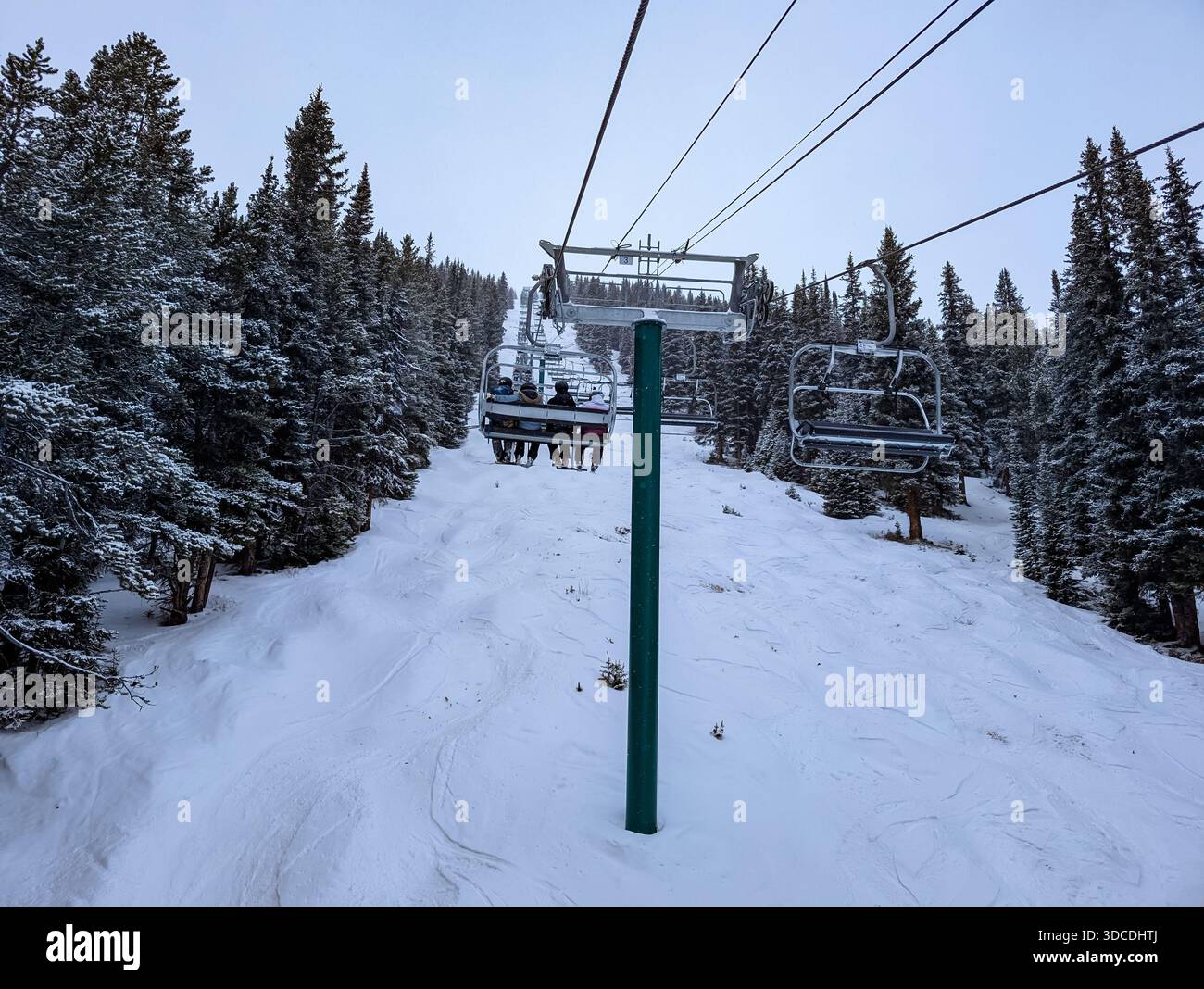 skieurs assis sur un télésiège dans une station de ski, pente bleue en contrebas, pendant la saison de ski active. Concept de station de ski, loisirs actifs. Sommet Banque D'Images