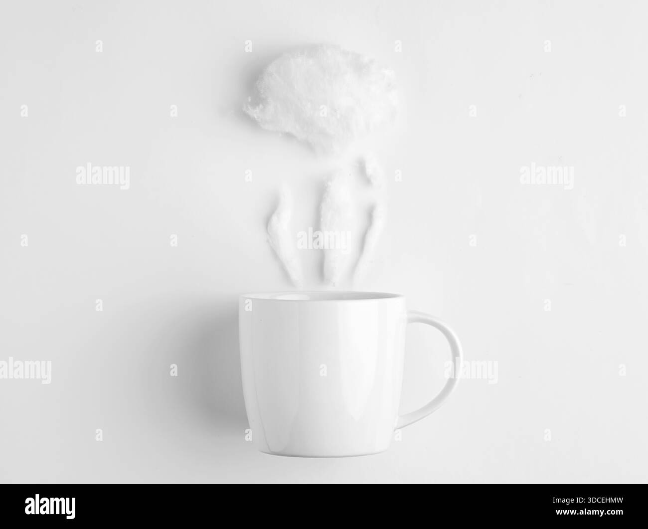Tasse blanche avec barbe à papa simulant la vapeur placée sur un fond blanc, représentant une boisson chaude Banque D'Images