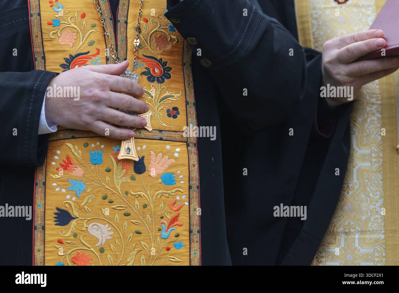 Détails avec les mains et la robe d'un prêtre orthodoxe chrétien. Banque D'Images