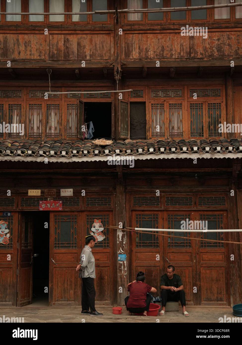 Qiandongnan, Chine - 30 septembre 2025 : vue sur l'architecture en bois vieilli, où le bois sombre et altéré contraste avec la fenêtre et le fi lumineux et ouverts Banque D'Images