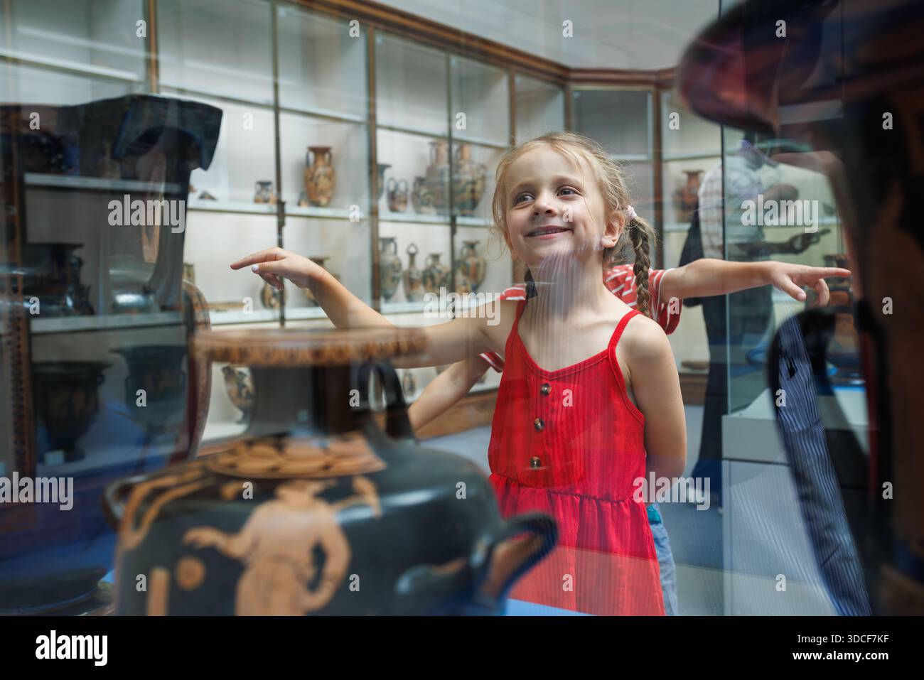 Les enfants fascinés par les objets historiques stockés dans une vitrine en voyage scolaire culturel Banque D'Images