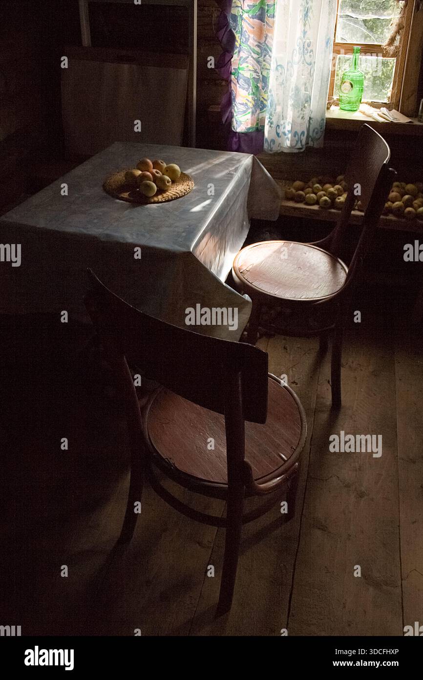 Intérieur de cuisine rustique ensoleillé avec table en bois et bouteille verte Banque D'Images