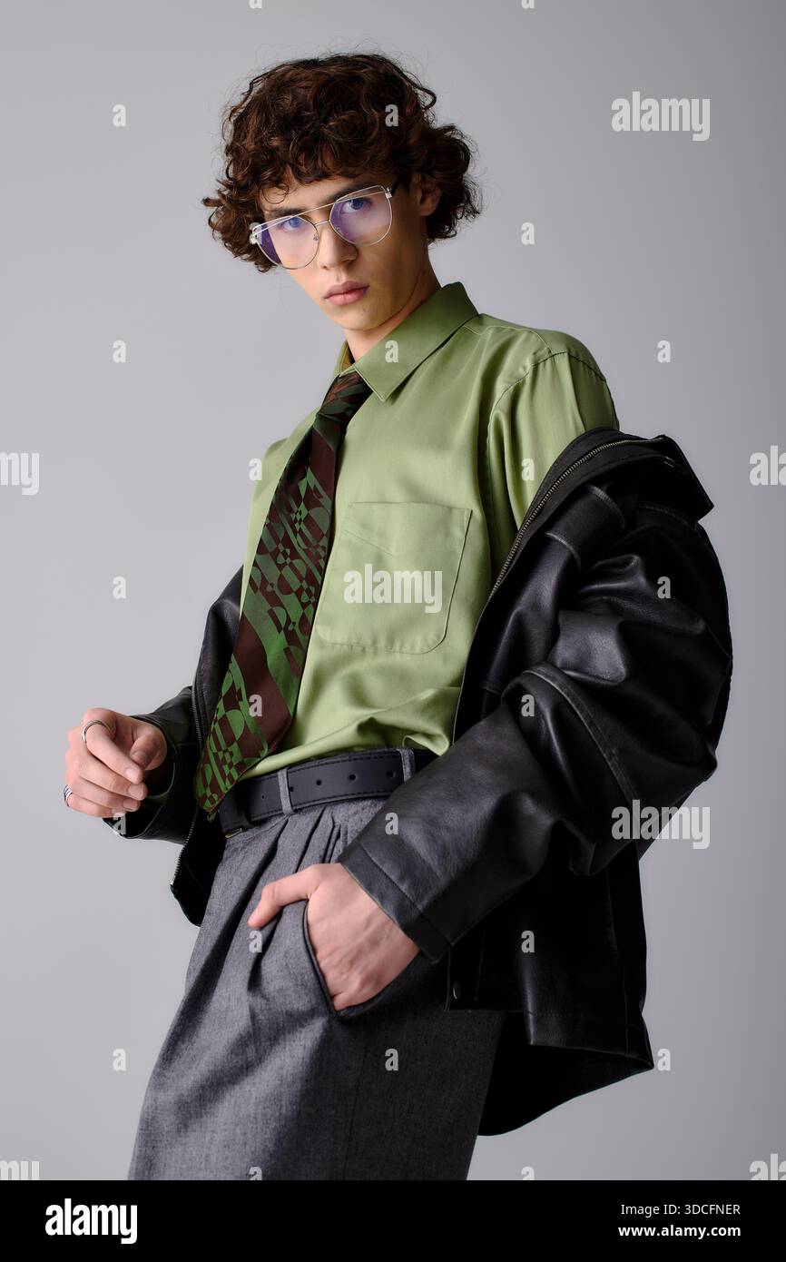 Beau homme présente une tenue tendance avec une touche de modernité dans un cadre contemporain. Banque D'Images