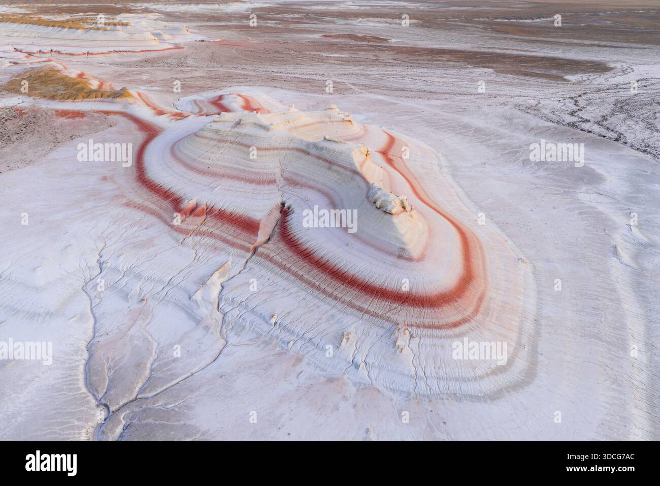 Vue aérienne d'un paysage surréaliste de formations rocheuses en couches avec des bandes rouges et blanches vibrantes créant un contraste visuel saisissant, Senek, Mangystau R. Banque D'Images