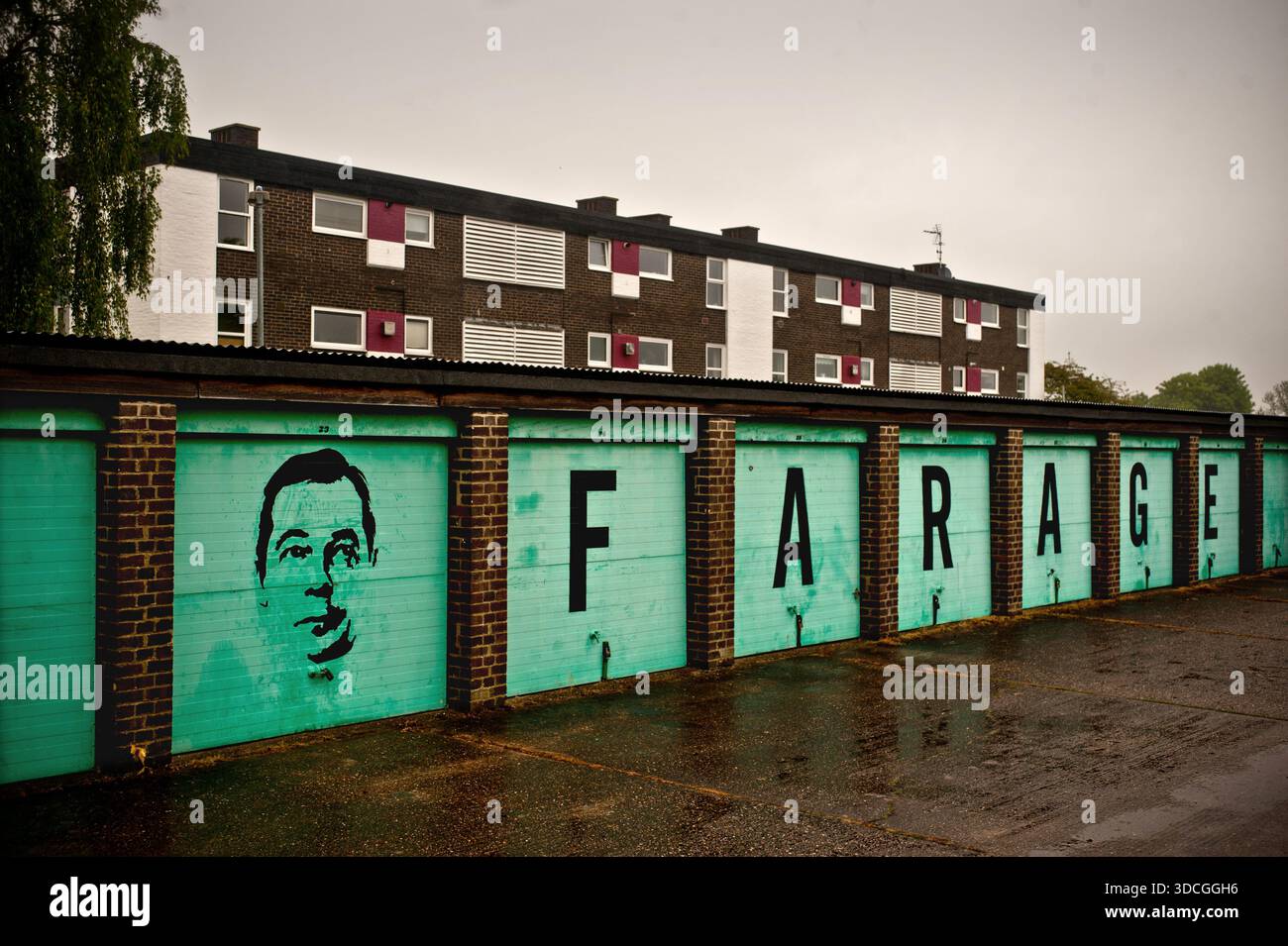 Une rangée de garages à Cambridge, Royaume-Uni graffinés avec une image de Nigel Farage. Banque D'Images