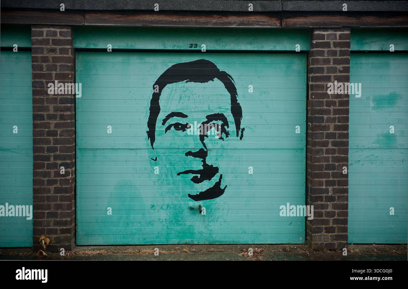Une rangée de garages à Cambridge, Royaume-Uni graffinés avec une image de Nigel Farage. Banque D'Images