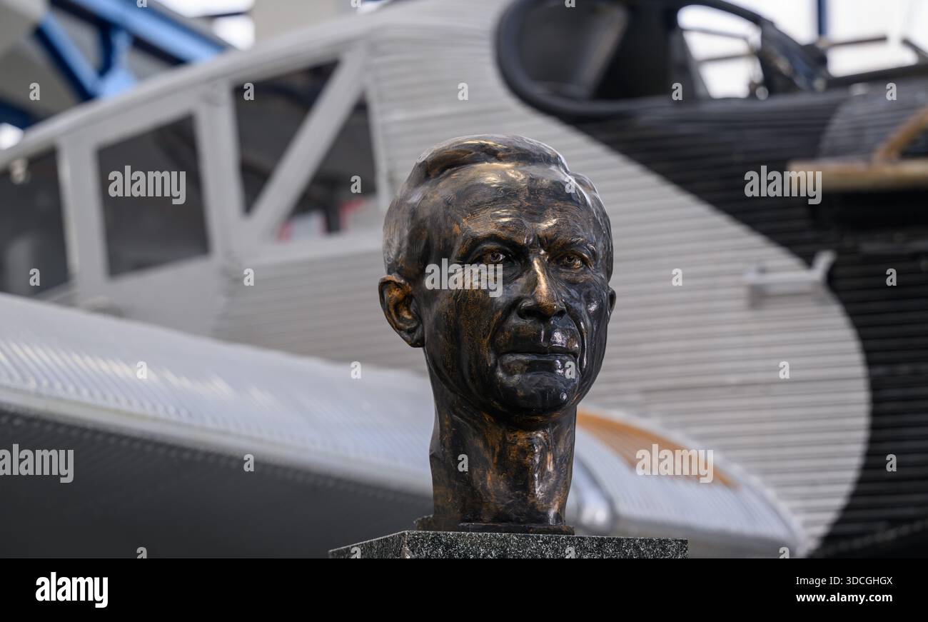 PRODUCTION - 18 décembre 2025, Saxe-Anhalt, Dessau-Roßlau : un buste portrait du concepteur d'avions Hugo Junkers se tient devant un Junkers F13 dans le Musée de technologie 'Hugo Junkers' de Dessau-Roßlau. Le musée se concentre sur le travail du concepteur d'avions et entrepreneur Hugo Junkers, de la technologie des appareils de chauffage et de gaz à l'ingénierie des moteurs et de la mécanique et à l'aviation. L'exposition centrale est un Junkers Ju restauré 52/3m. Une autre partie de l'exposition est consacrée à la construction aéronautique en RDA entre 1954 et 1961. Photo : Hendrik Schmidt/dpa Banque D'Images
