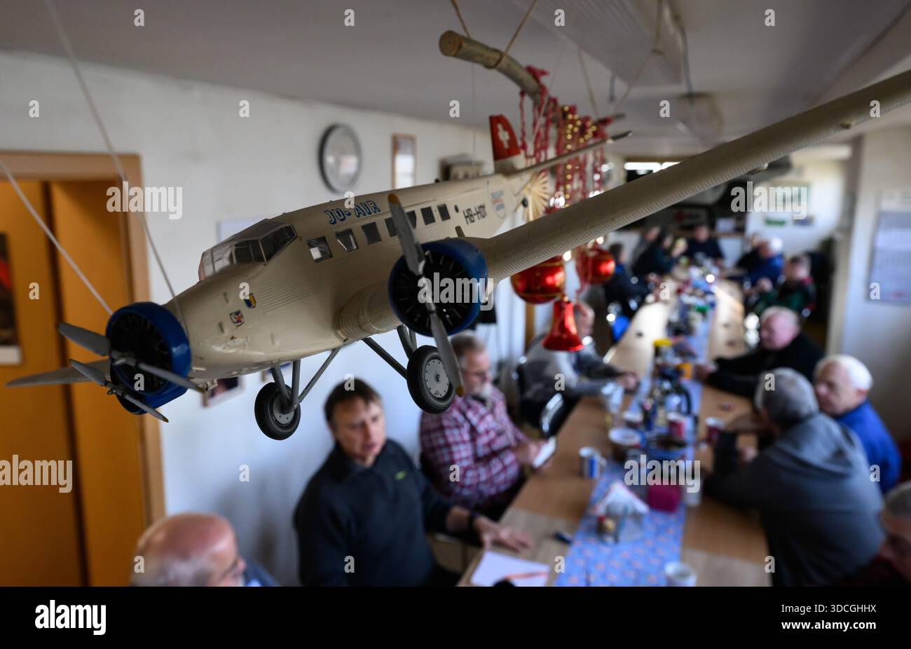 PRODUCTION - 18 décembre 2025, Saxe-Anhalt, Dessau-Roßlau : des personnes âgées du Musée technologique Hugo Junkers sont assises dans la salle de pause de l'atelier pendant une pause de travail à Dessau-Roßlau. Le musée se concentre sur le travail du concepteur d'avions et entrepreneur Hugo Junkers, de la technologie des appareils de chauffage et de gaz à l'ingénierie des moteurs et de la mécanique et à l'aviation. L'exposition centrale est un Junkers Ju restauré 52/3m. Une autre partie de l'exposition est consacrée à la construction aéronautique en RDA entre 1954 et 1961. Photo : Hendrik Schmidt/dpa Banque D'Images