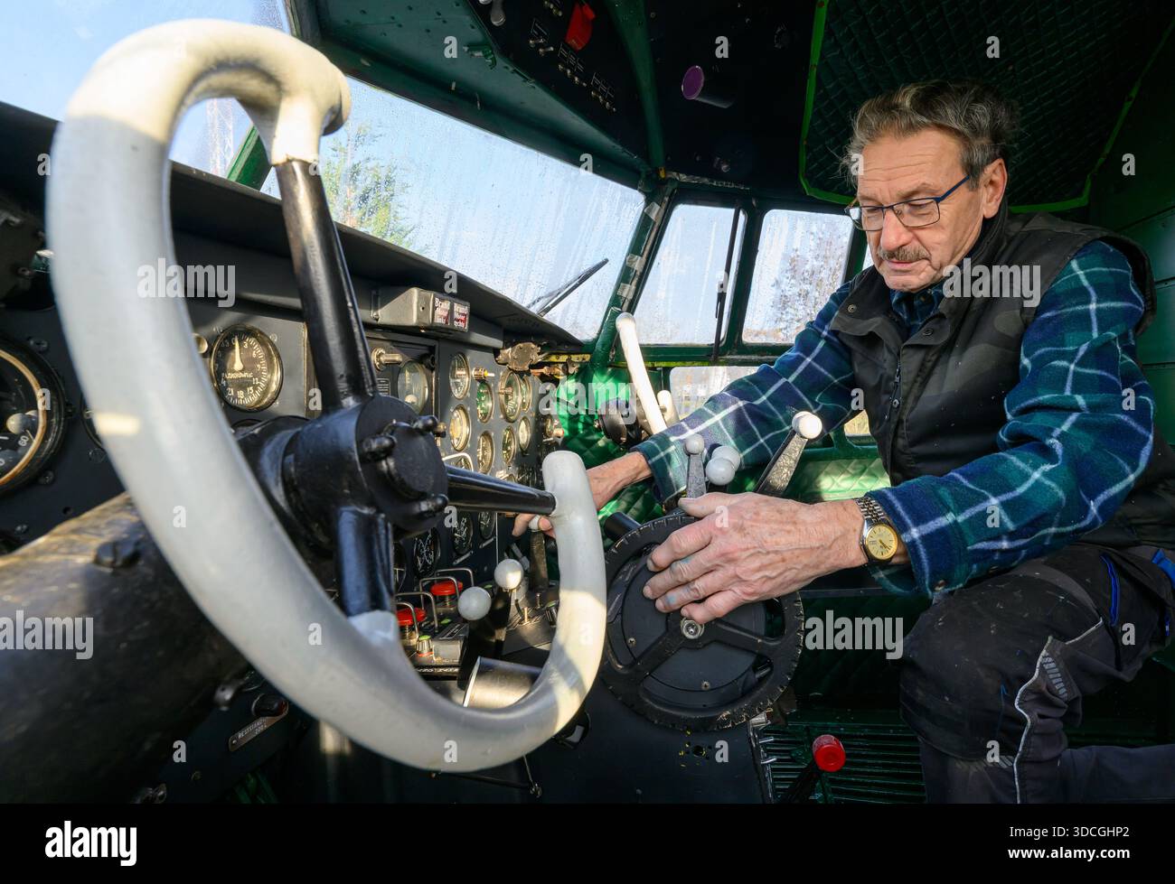 PRODUCTION - 18 décembre 2025, Saxe-Anhalt, Dessau-Roßlau : Uwe Liesche des amis du Musée de technologie Hugo Junkers de Dessau-Roßlau est occupé dans le cockpit d'un il-14P. de 1957 L'avion de l'usine aéronautique de Dresde est actuellement en cours de restauration par des membres de haut rang de l'association. Le musée se concentre sur le travail du concepteur d'avions et entrepreneur Hugo Junkers, de la technologie des appareils de chauffage et de gaz à l'ingénierie des moteurs et de la mécanique et à l'aviation. L'exposition centrale est un Junkers Ju restauré 52/3m. Une autre partie de l'exposition est consacrée à la construction d'avions en Banque D'Images