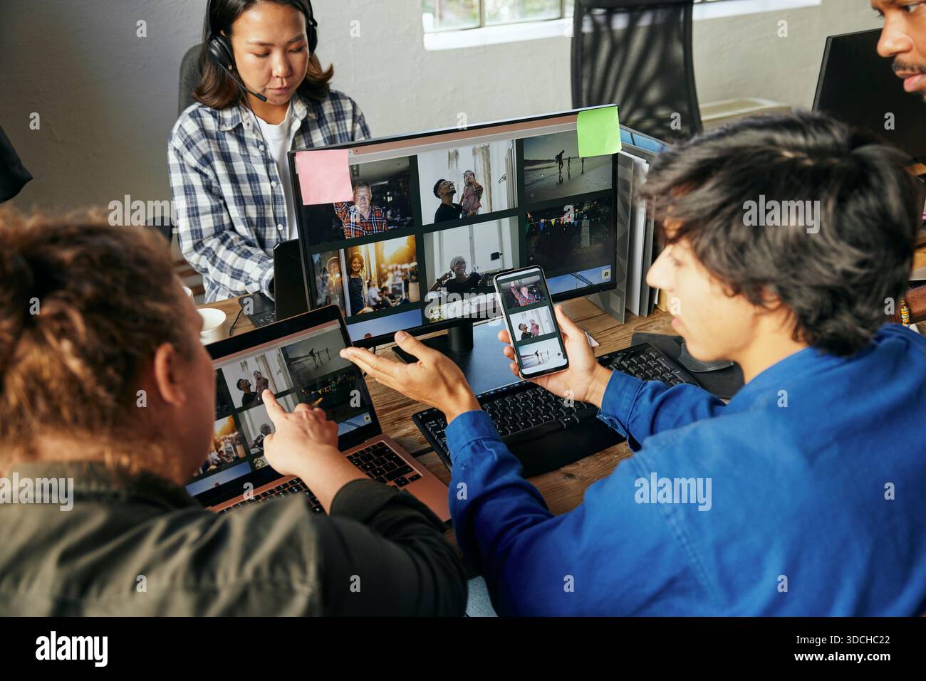 Vue à angle élevé de professionnel de la technologie masculine sélectionnant des images sur ordinateur portable avec collègue féminine au bureau Banque D'Images