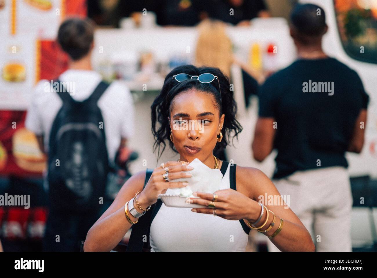 Femme appréciant le hot dog au festival de nourriture Banque D'Images