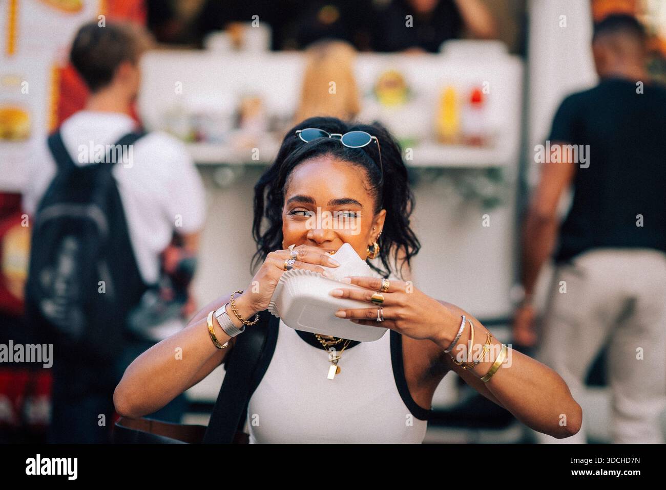Femme mangeant hot dog tout en profitant au festival de nourriture Banque D'Images