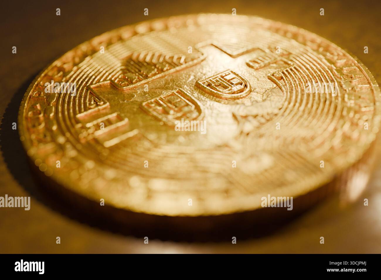 Gros plan d'un Bitcoin doré brillant reposant sur une surface réfléchissante, symbolisant la crypto-monnaie, l'argent numérique, la technologie blockchain, l'investissement, et mo Banque D'Images