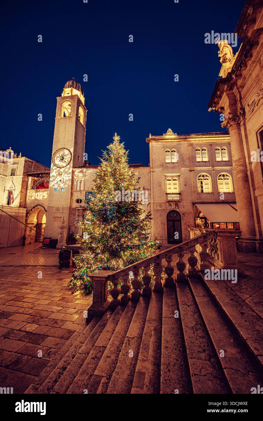 Vue d'un arbre de Noël scintillant avec des lumières festives se dresse fièrement sur une place historique, encadrée par d'anciens bâtiments en pierre, Dubrovnik, Dubrovnik-N. Banque D'Images